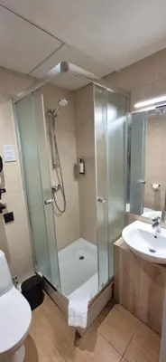 a bathroom with a shower and a toilet and a sink at Private Room - Hotel Building in Vilnius