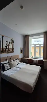 a bedroom with a large bed and a window at Cozy Private Room in Corner Building in Vilnius