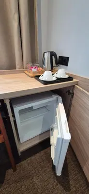 a microwave sitting under a table in a room at Cozy Private Room in Corner Building in Vilnius