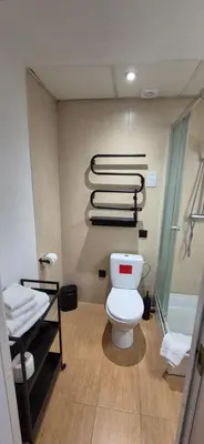 a bathroom with a toilet and some towels at Cozy Private Room in Corner Building in Vilnius