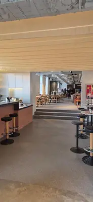 a cafeteria with tables and chairs in a building at Cozy Private Room in Corner Building in Vilnius