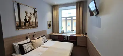 a bedroom with a bed and a desk and a television at Cozy Private Room in Corner Building in Vilnius