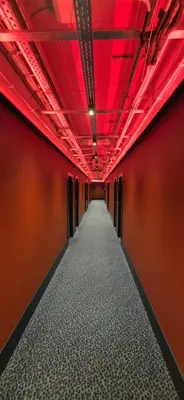 a long corridor with red lights on the ceiling at Cozy Private Room in Corner Building in Vilnius