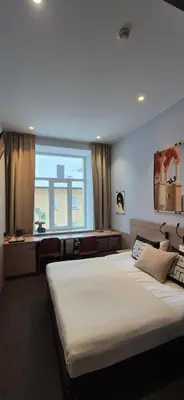 a bedroom with a large bed and a desk at Private Double Room in Corner Building in Vilnius