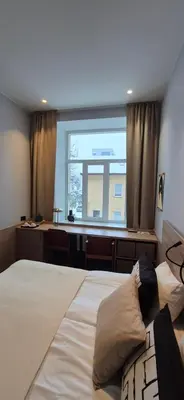 a bedroom with a bed and a desk and a window at Private Double Room in Corner Building in Vilnius