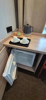 a table with two plates and a pot on top of it at Private Double Room in Corner Building in Vilnius