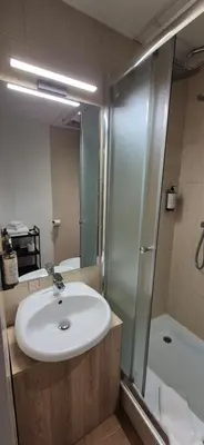 a bathroom with a sink and a shower at Private Double Room in Corner Building in Vilnius