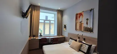 a bedroom with a bed and a desk and a window at Private Double Room in Corner Building in Vilnius