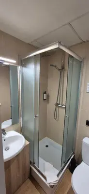 a bathroom with a shower and a sink and a toilet at Private Double Room in Corner Building in Vilnius