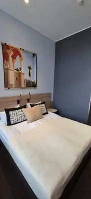 a large white bed in a blue room at Private Double Room in Corner Building in Vilnius