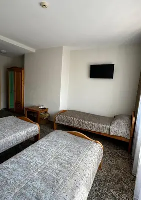 a room with two beds and a flat screen tv at Keta in Marijampolė