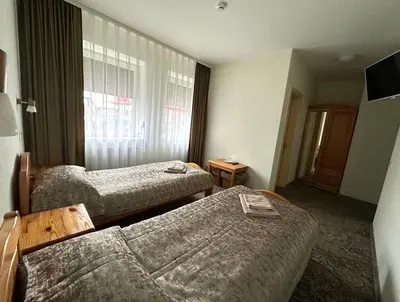 a hotel room with two beds and a couch at Keta in Marijampolė