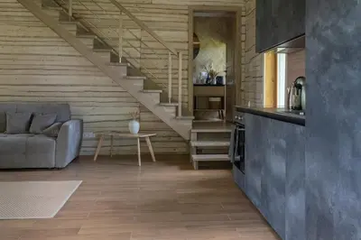 a living room with a couch and a staircase at Panekelpių vienkiemis in Aguriškės