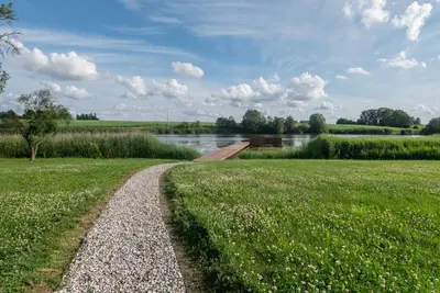 a path through a field next to a river at Panekelpių vienkiemis in Aguriškės