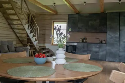 a dining room table with a vase of flowers on it at Panekelpių vienkiemis in Aguriškės