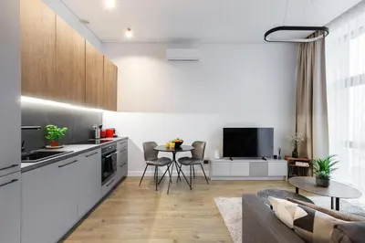 a kitchen and living room with a couch and a table at Cozy Top-Floor Apartment with City Views Vilnius in Vilnius