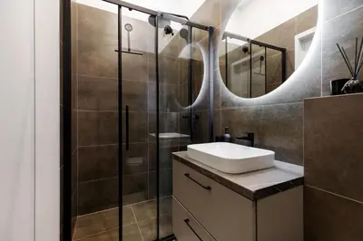 a bathroom with a sink and a shower at Cozy Top-Floor Apartment with City Views Vilnius in Vilnius