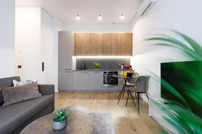 a living room with a couch and a kitchen at Cozy Top-Floor Apartment with City Views Vilnius in Vilnius