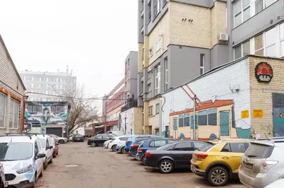 a row of cars parked on a city street at Cozy Top-Floor Apartment with City Views Vilnius in Vilnius