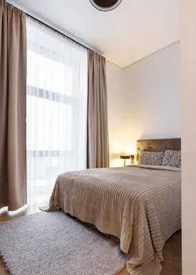 a bedroom with a bed and a large window at Cozy Top-Floor Apartment with City Views Vilnius in Vilnius