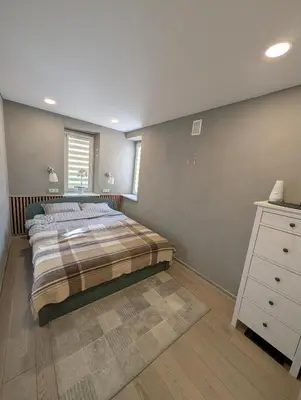 a bedroom with a bed and a white dresser at Jaukūs apartamentai prie Šiaulių arenos in Šiauliai