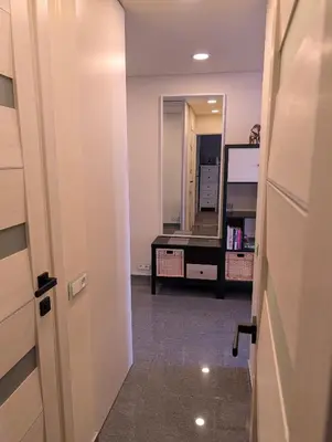 a hallway with a room with a mirror and a table at Jaukūs apartamentai prie Šiaulių arenos in Šiauliai