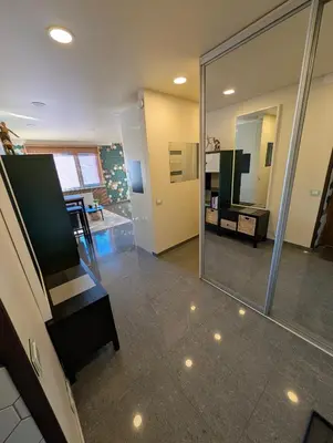 a view of a living room with a mirror at Jaukūs apartamentai prie Šiaulių arenos in Šiauliai