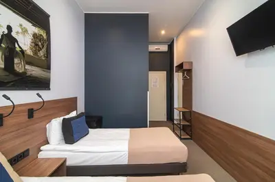 a hotel room with a bed and a flat screen tv at Hotel Premium Rooms in Vilnius