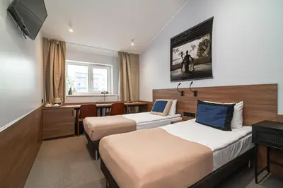 a hotel room with two beds and a desk at Hotel Premium Rooms in Vilnius
