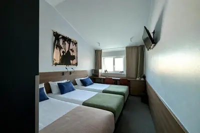 a hotel room with two beds and a desk at Hotel Premium Rooms in Vilnius