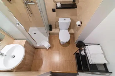 a bathroom with a toilet and a sink and a bath tub at Hotel Premium Rooms in Vilnius
