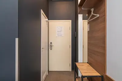 a hallway with a white door and a wooden table at Hotel Premium Rooms in Vilnius