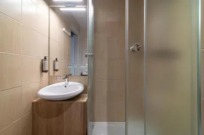 a bathroom with a sink and a glass shower at Hotel Premium Rooms in Vilnius