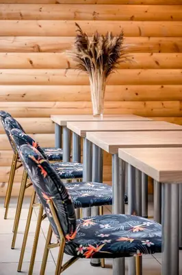a table with two chairs and a vase of flowers on it at HOME Studios & Apartments Old town 10 min walk 24-hours Front desk Vilnius in Vilnius