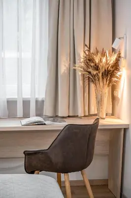 a desk with a chair in front of a window at HOME Studios & Apartments Old town 10 min walk 24-hours Front desk Vilnius in Vilnius