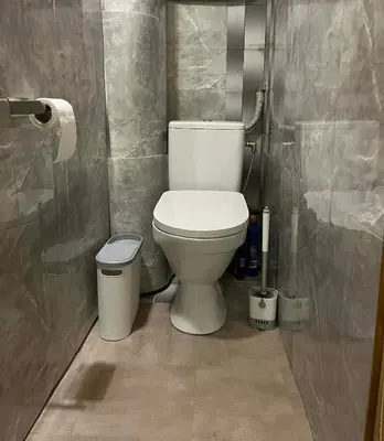 a bathroom with a toilet and a trash can at Šiaurės Butas in Kaunas