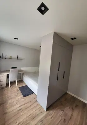 a small bedroom with a bed and a desk at Ekonomiskas in Vilnius