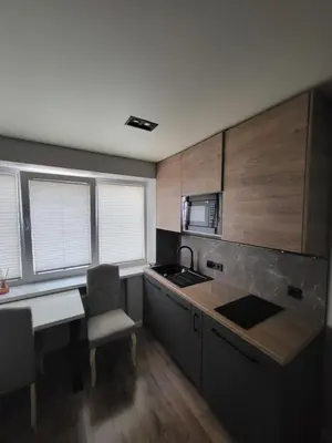 a kitchen with a sink and a table with a chair at Ekonomiskas in Vilnius