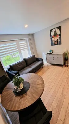 a living room with a table and a couch at Trumpalaikė butų nuoma Kaune prie Klinikų STUDIJA B SELF CHECK IN in Kaunas