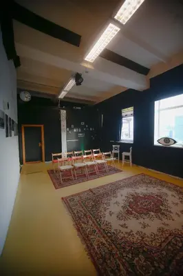 a room with tables and chairs and a rug at Micro Art Residence & Party Event Venue in Vilnius