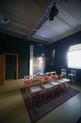 a room with a group of chairs and a screen at Micro Art Residence & Party Event Venue in Vilnius