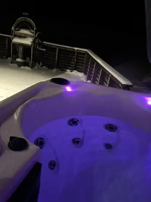 a purple bath tub with lights in the snow at Pakarklių sodyba in Šeiminiškiai