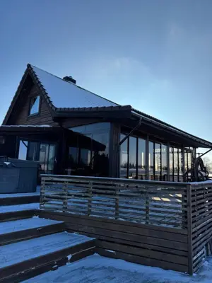 a house with glass windows and a roof at Pakarklių sodyba in Šeiminiškiai