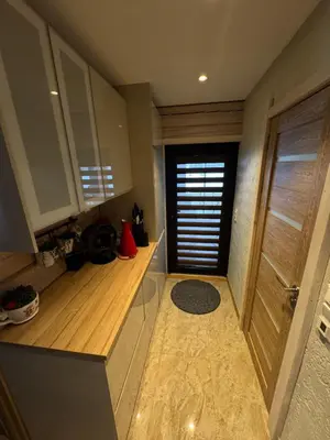 a kitchen with a wooden floor and a door at Pakarklių sodyba in Šeiminiškiai