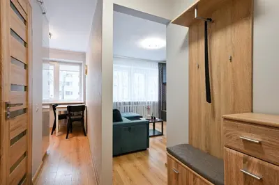 two views of a living room and a kitchen in a apartment at City Essetials Apartmets in Kaunas