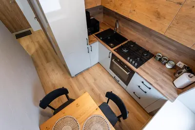 an overhead view of a kitchen with a stove and a table at City Essetials Apartmets in Kaunas