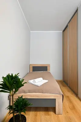 a bedroom with a bed and a potted plant at City Essetials Apartmets in Kaunas