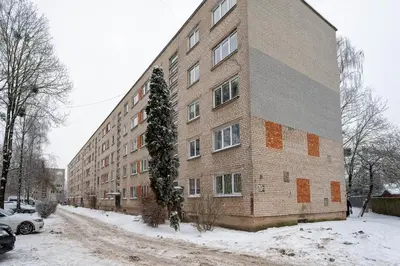 a large brick building with snow on the side of it at City Essetials Apartmets in Kaunas