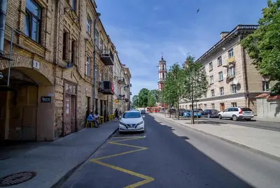 a car parked on the side of a city street at Spacious and Bright Lukiskiu Square Apartment in Vilnius