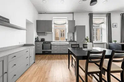 a kitchen with a table and chairs in a room at Spacious and Bright Lukiskiu Square Apartment in Vilnius